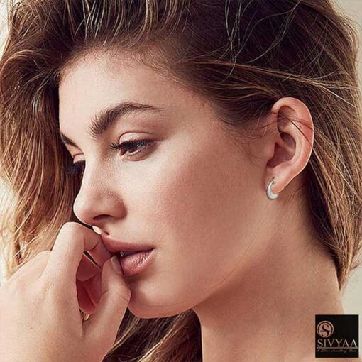 female model wearing- SIVYAA Kaju Shape flower textured pure silver bali