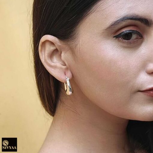 model wearing1-925 sterling silver oxidized crescent tribal hoop earrings with filigree central design